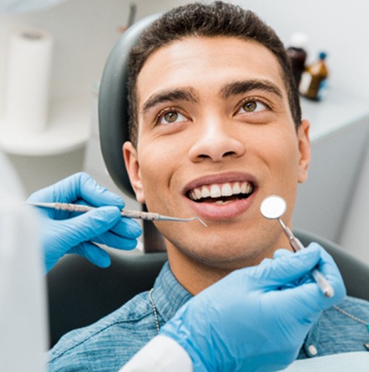 man smiling while visiting dentist  