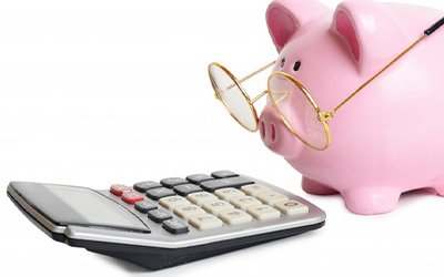 Piggy bank with glasses looking at a calculator