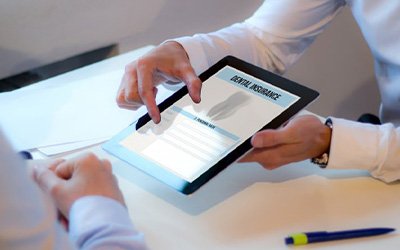 Dentist and patient reviewing dental insurance on an e-reader