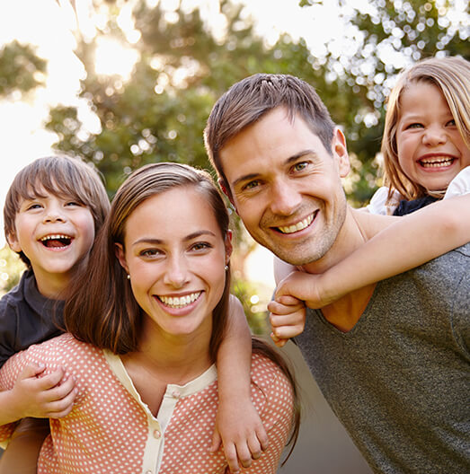 Family of four smiling outdoors