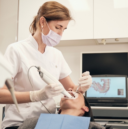 Dental team member taking digital dental impressions of a patient's teeth