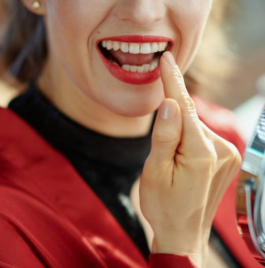 a patient checking their teeth with a mirror