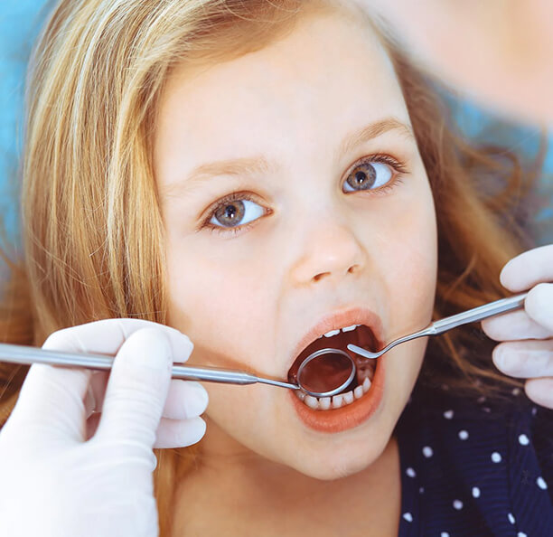 Young girl getting a dental exam from children's dentist in Northbrook