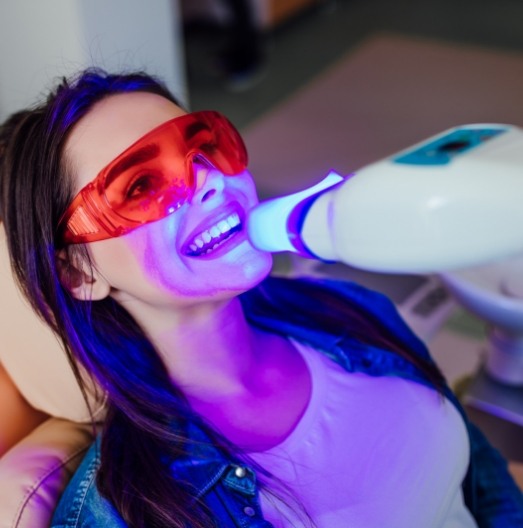 Woman getting professional teeth whitening in dental office