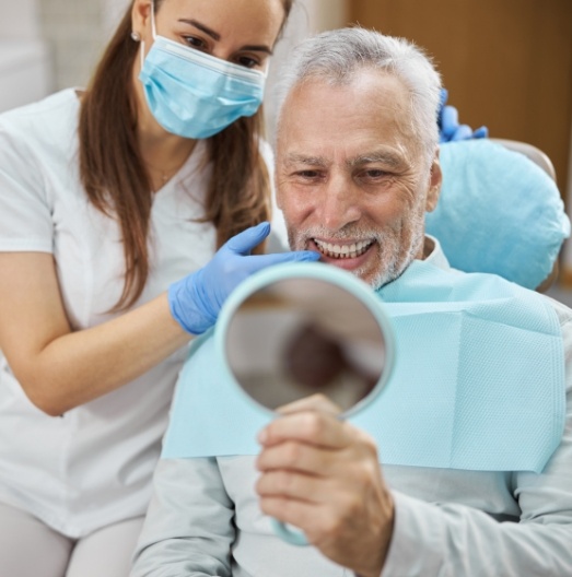 Senior dental patient seeing his smile in a mirror