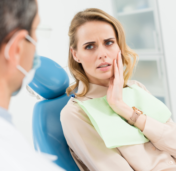 Woman holding her jaw in pain while talking to emergency dentist in Northbrook