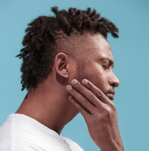 Side profile of man holding his jaw in pain
