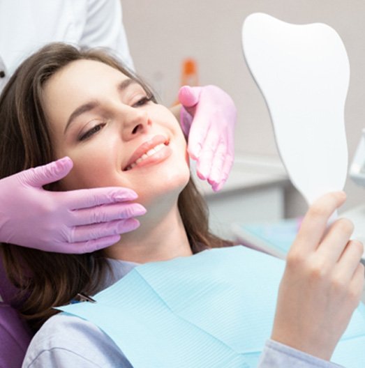 woman smiling while sitting in dental chair