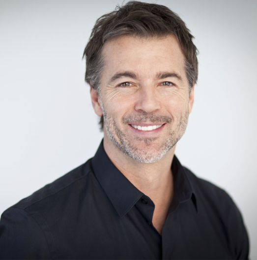 Smiling older man in black collared shirt