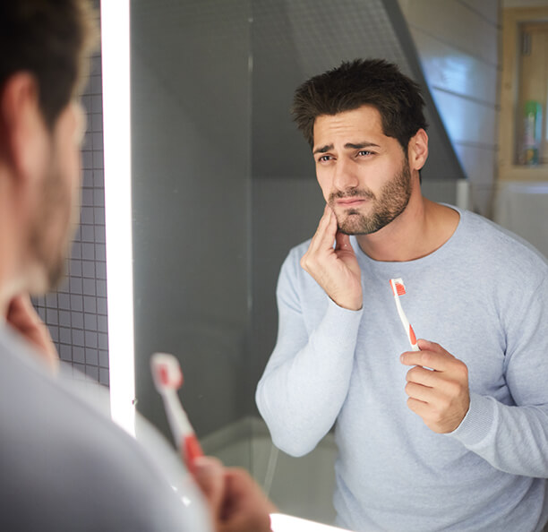 Man holding his jaw in pain who needs T M J treatment in Northbrook