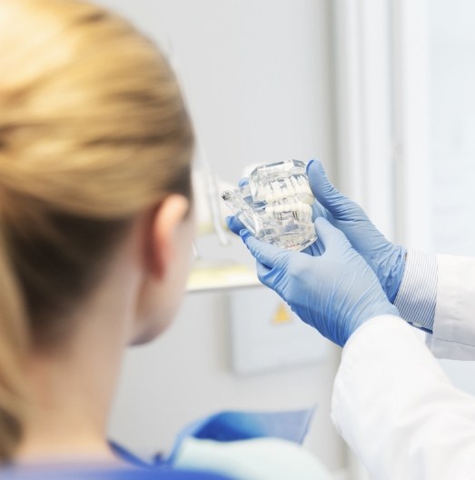 Dentist showing a patient a model of the teeth