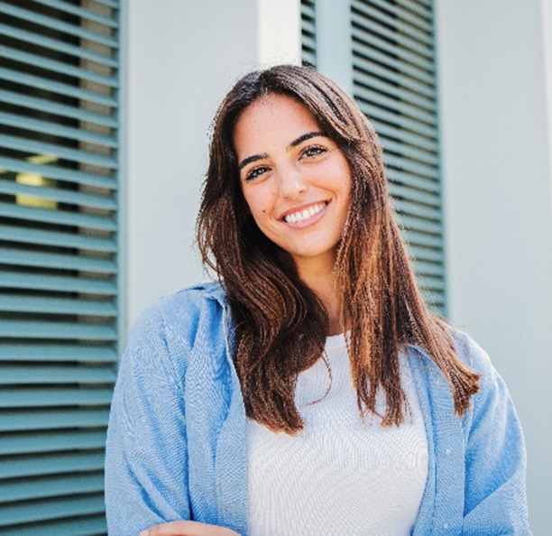 Woman with white teeth smiling while standing outside