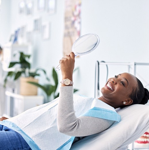 Woman smiling while looking at reflection in mirror