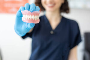 Dental technician holding dentures